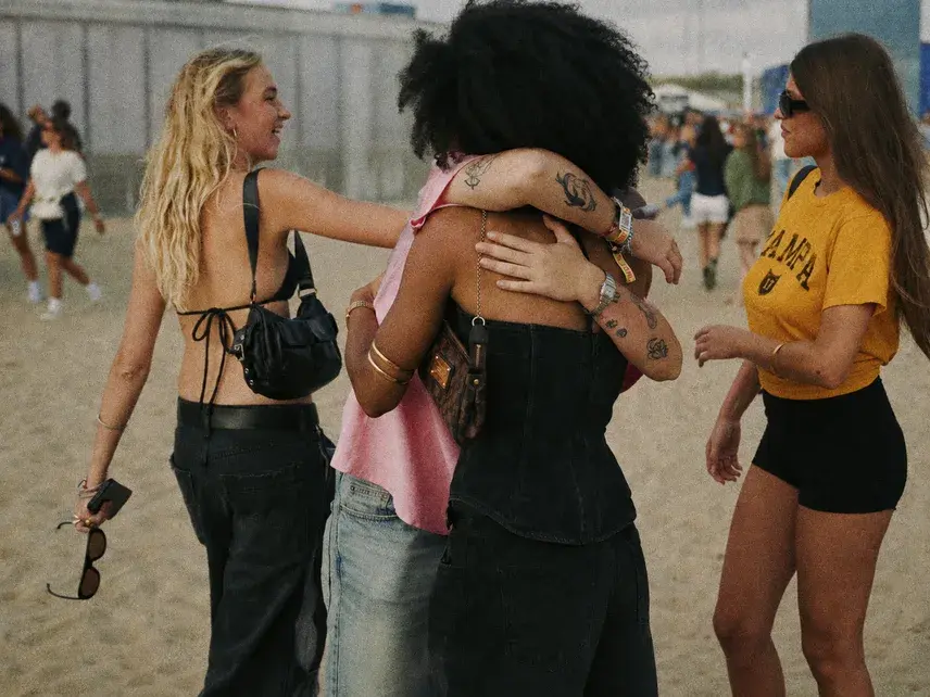 Friends embracing on the beach at WECANDANCE