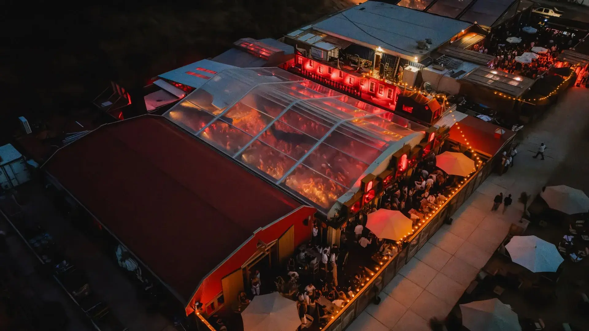 An aerial view of Colorado Charlie’s illuminated beachfront venue at dusk