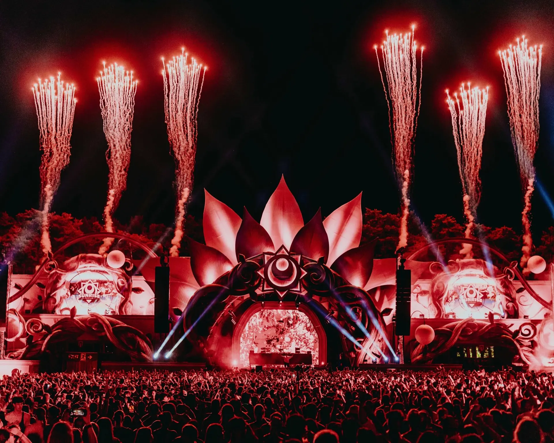 Fireworks rising above Sunrise Festival’s lotus-shaped main stage at night, in front of a packed crowd