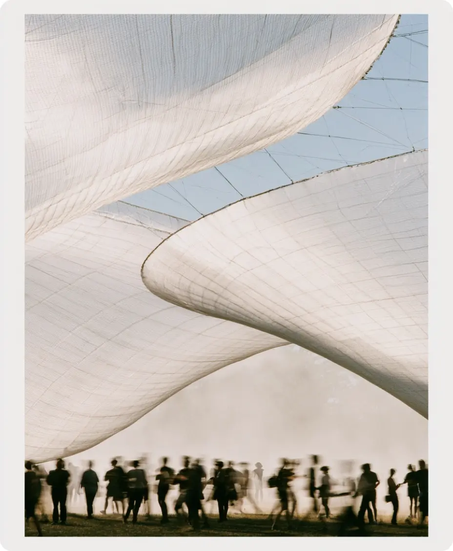 A crowd walking under an inflatable festival structure